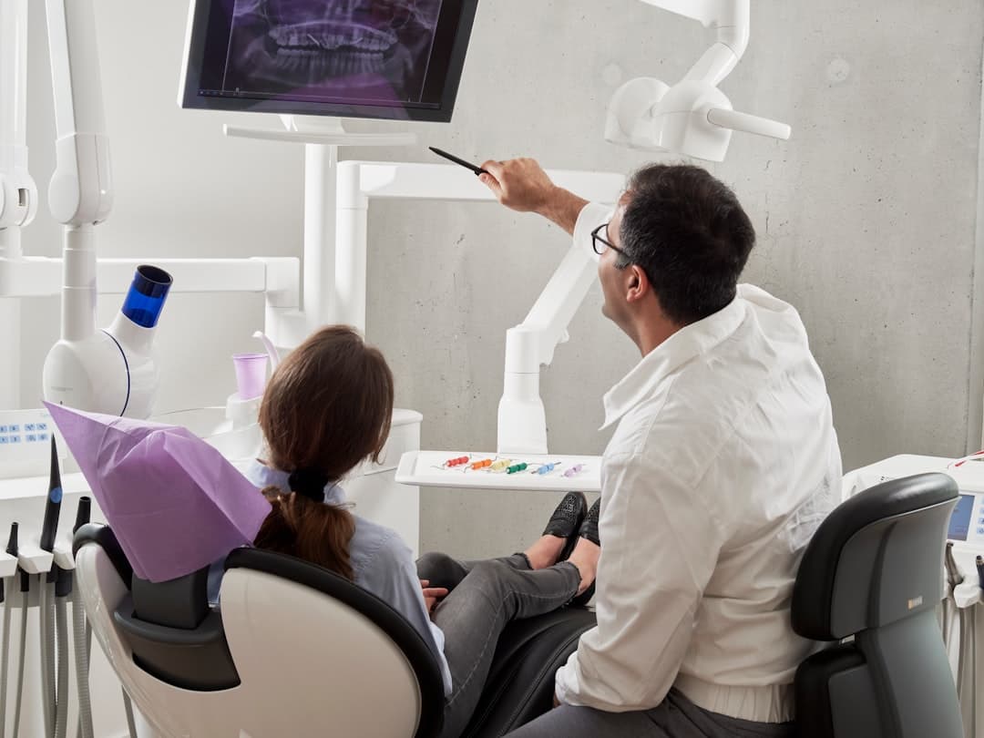 A dental team in a meeting room discussing patient recall and reactivation strategies to improve clinic retention rates.
