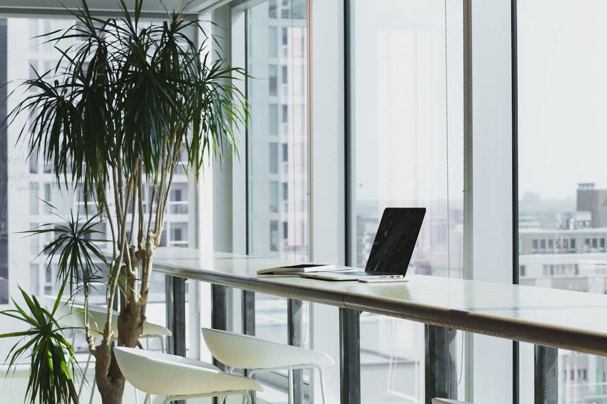 Minimal workspace with a desk and chair near a large window for focused private practice work