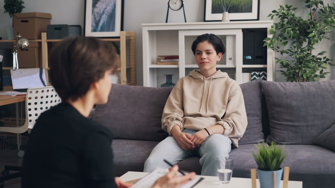 A therapist reviewing documents at a desk, planning the role and responsibilities for a new associate therapist.
