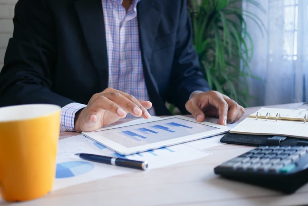 A consultant analyzing financial reports on a laptop, illustrating the process of determining consulting costs for therapy practices.