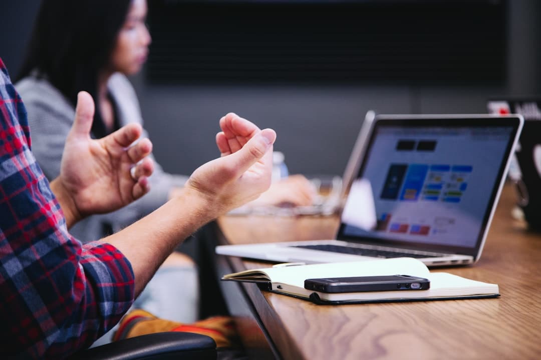 Two colleagues consulting over a project in a bright office, illustrating the benefits of done-with-you marketing approaches.