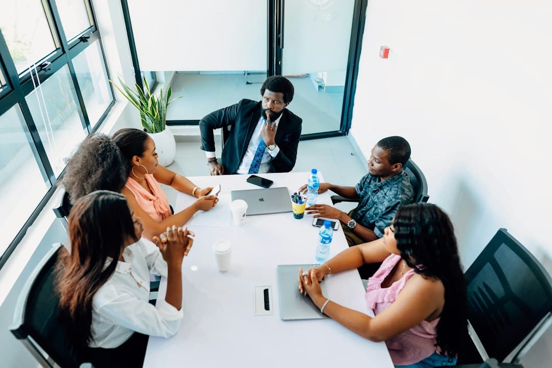 A small team discussing healthcare marketing strategies in a modern office, focusing on Google Ads compliance.