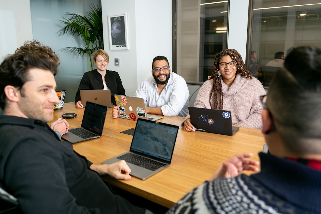 A group of professionals in a meeting discussing referral pathways, emphasizing collaboration in speech-language pathology marketing.